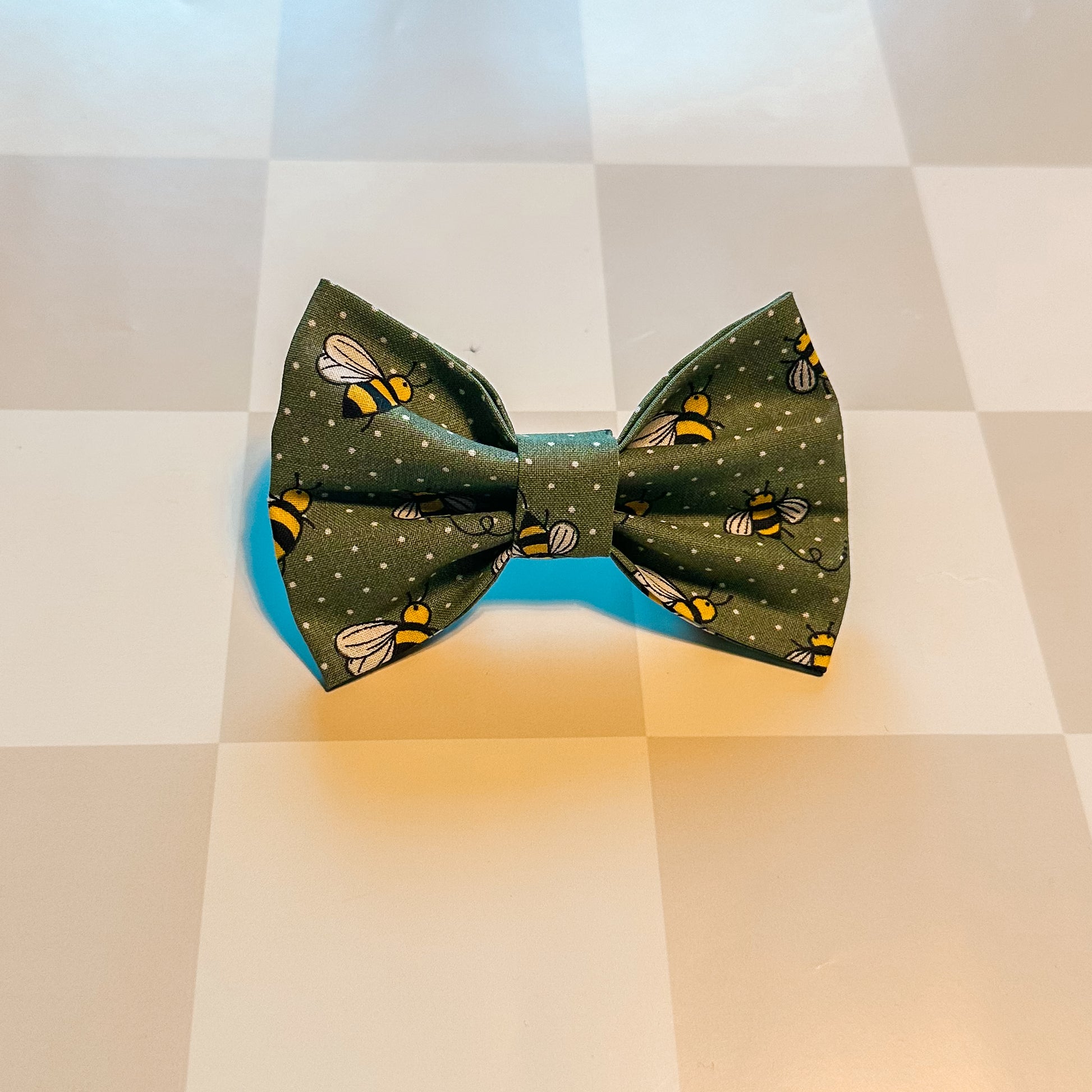 Green bow tie with bee pattern on a checkered background