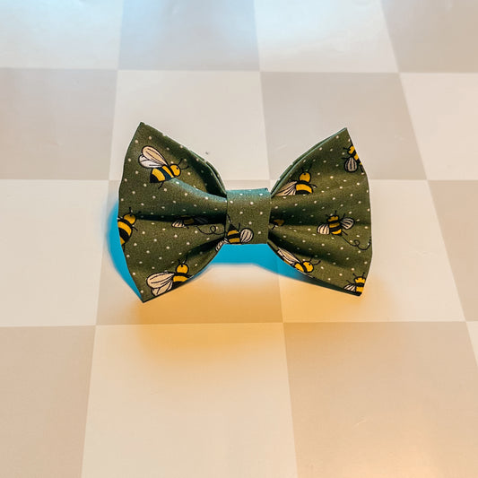 Green bow tie with bee pattern on a checkered background