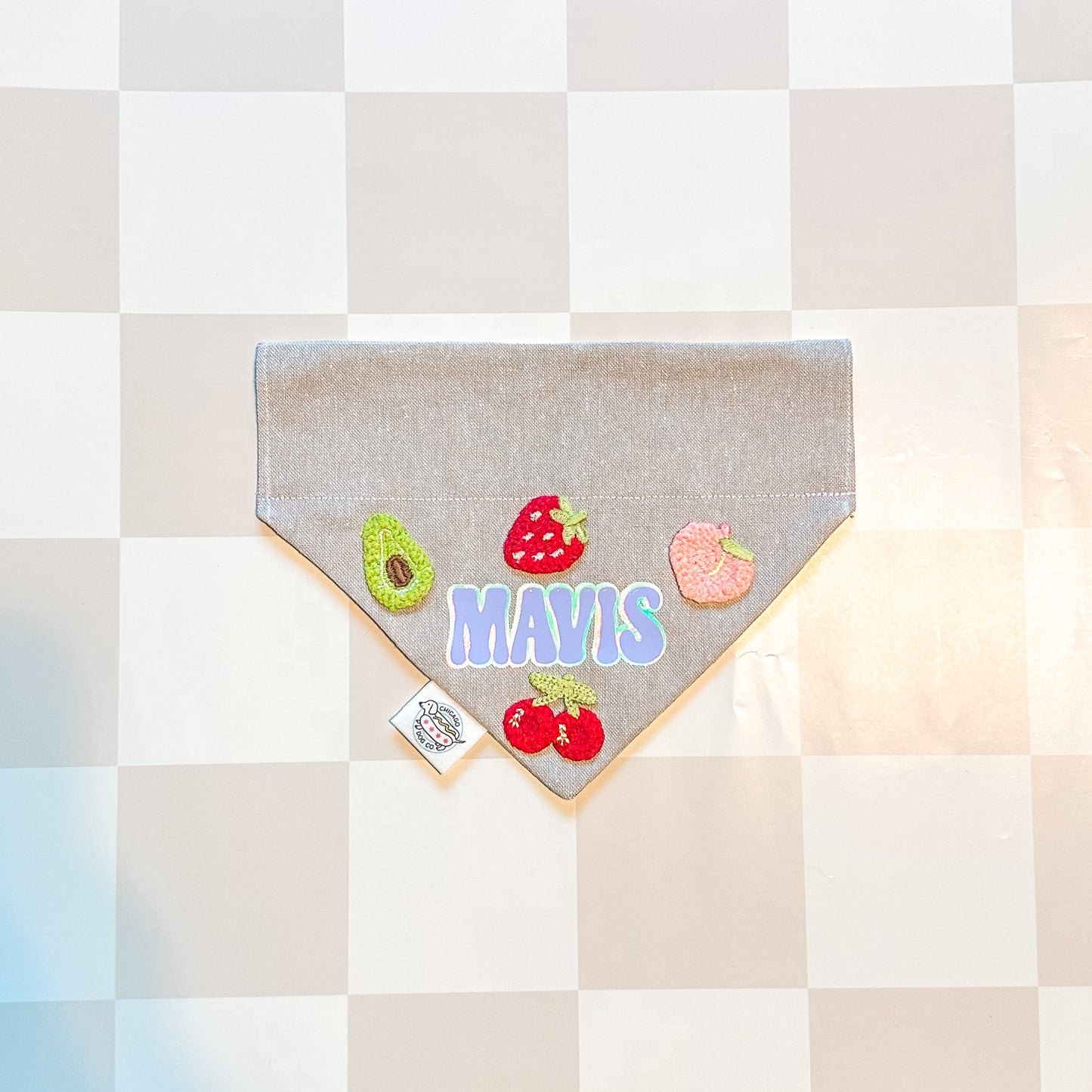 Gray bandana with colorful fruit designs and name personalization' text on a checkered background